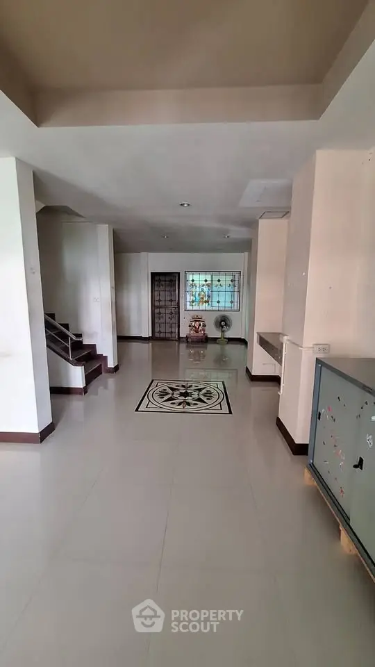 Spacious interior with elegant tile design and staircase, ideal for modern living.