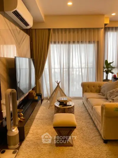 Luxurious living room with elegant decor, large TV, and plush seating, perfect for relaxation and entertainment.