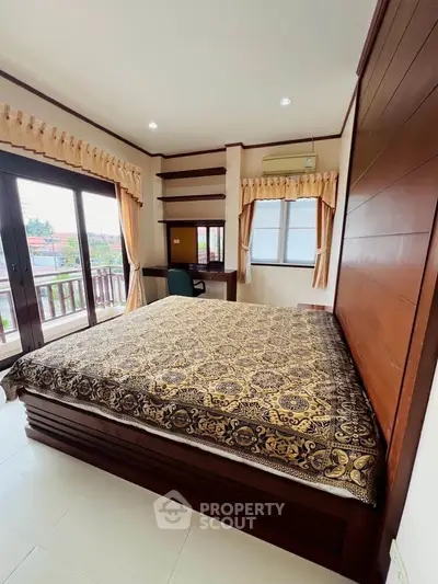 Spacious bedroom with elegant decor and balcony access in a modern home.