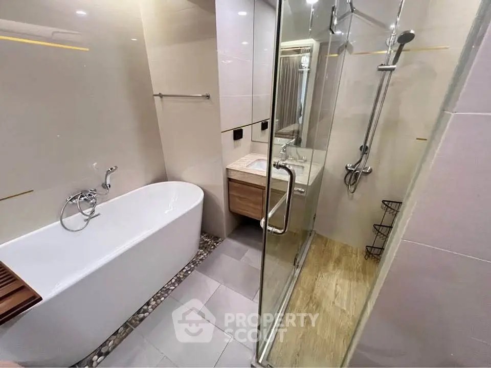 Modern bathroom with elegant bathtub and glass shower enclosure