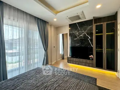 Luxurious bedroom with modern decor and large window offering natural light