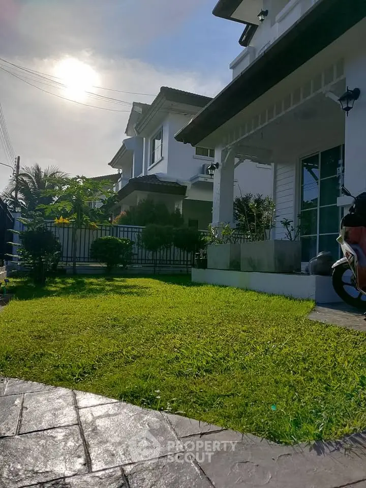 Charming suburban home with lush green lawn and modern architecture under a sunny sky.