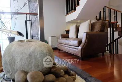 Stylish modern living room with leather sofa and unique stone water feature