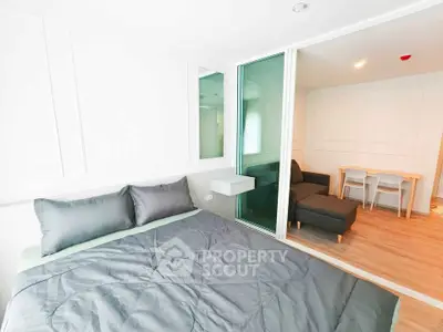 Modern bedroom with sliding glass door to cozy living area in stylish apartment