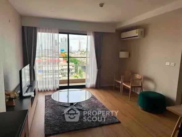 Spacious living room with city view, modern furniture, and large windows for natural light.