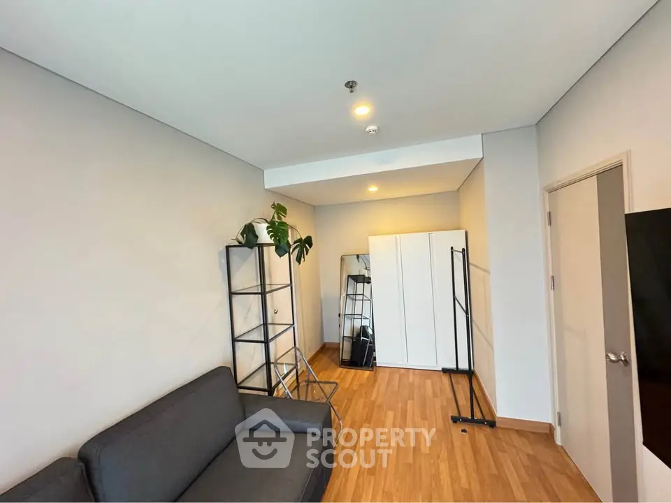 Modern living room with sleek furniture and wooden flooring, perfect for urban living.