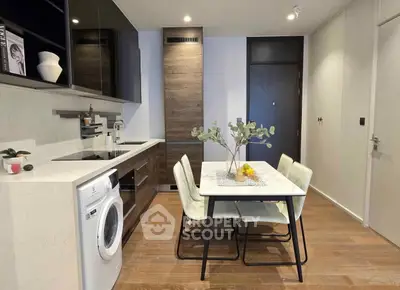Modern kitchen with integrated washing machine and sleek dining area.