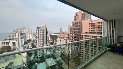 Stunning high-rise balcony view overlooking cityscape and ocean horizon.