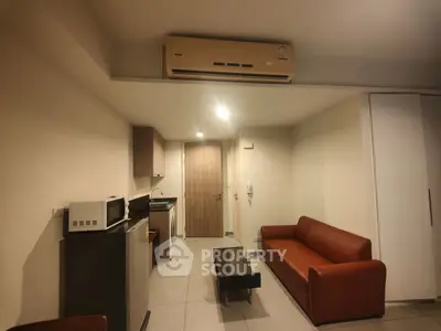 Cozy studio apartment with modern kitchenette and comfortable seating area.