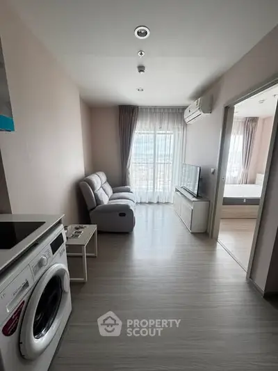 Modern living room with washing machine and TV, bright natural light