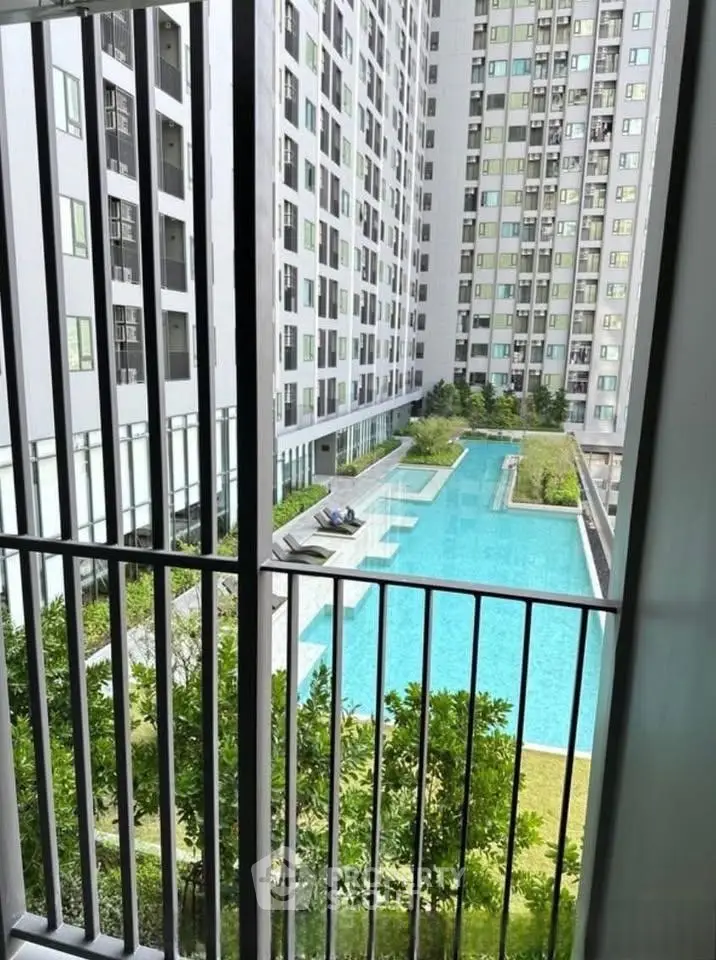 Modern apartment complex with pool view from balcony, showcasing urban living.