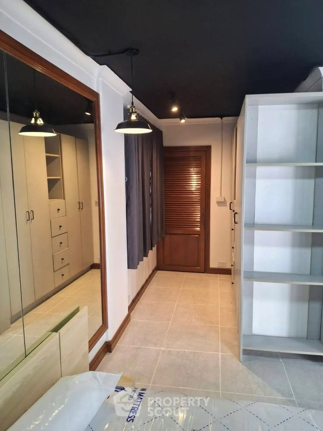 Modern bedroom with mirrored wardrobe and sleek lighting