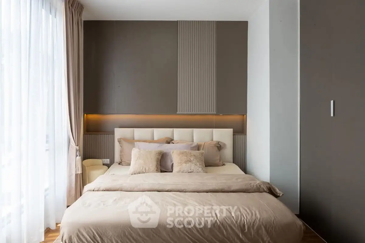 Luxurious bedroom with elegant decor and natural light, featuring a plush bed and stylish accents.