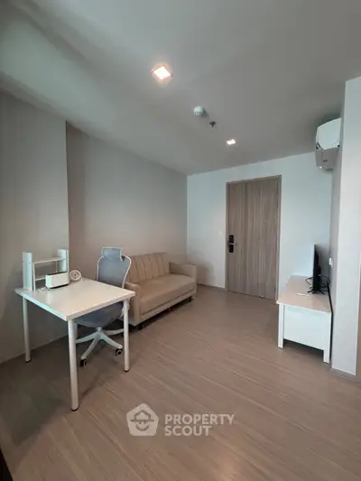 Modern living room with sleek furniture and minimalist design, featuring a cozy sofa and a stylish desk.