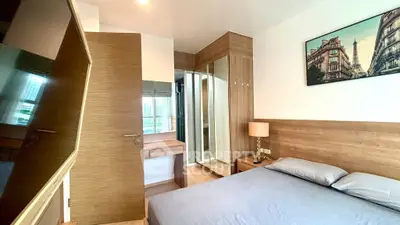 Modern bedroom with wooden accents and large mirror reflecting natural light.