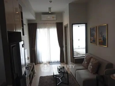 Modern living room with cozy sofa, stylish decor, and natural light from large window.