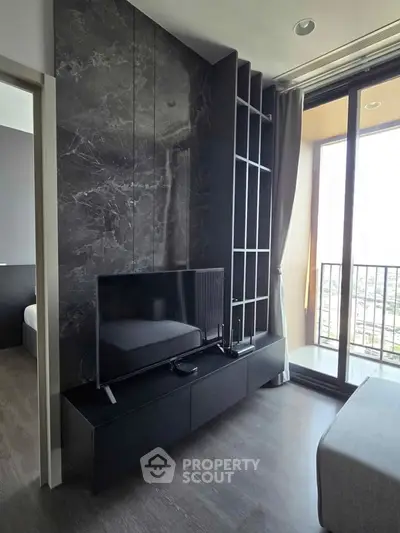 Modern living room with sleek black TV stand and large window balcony view