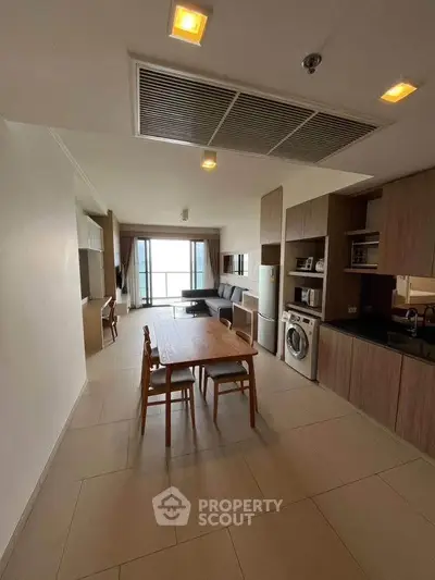 Spacious open-layout kitchen and living area with modern appliances and dining set.
