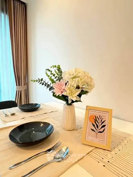 Elegant dining setup with floral centerpiece in modern apartment