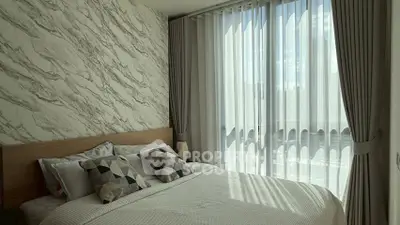 Modern bedroom with stylish decor and large window offering natural light