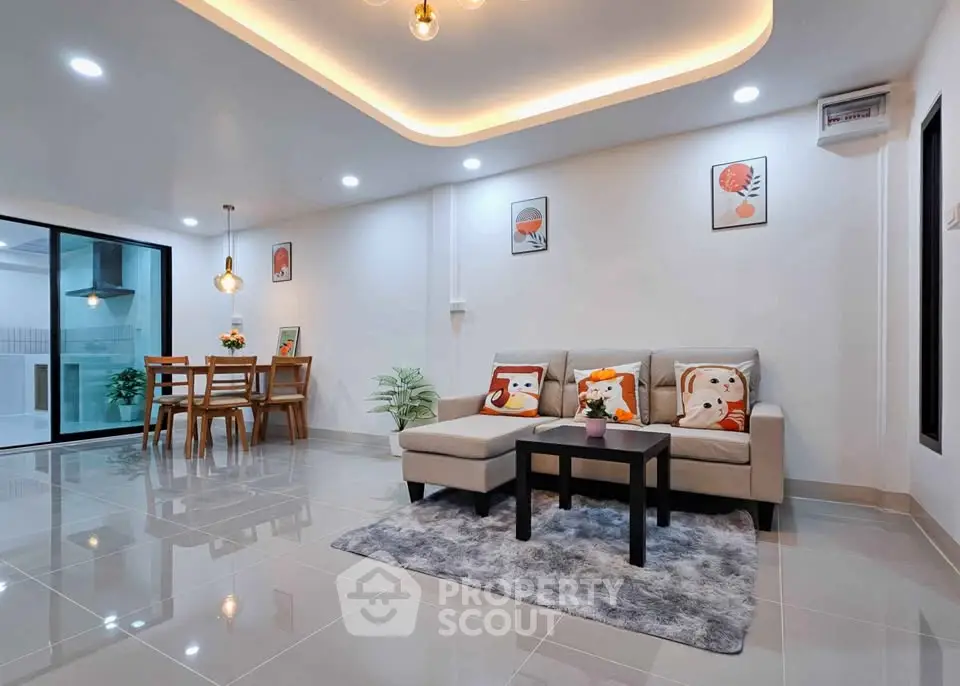 Spacious modern living room with elegant decor and open dining area, perfect for family gatherings.