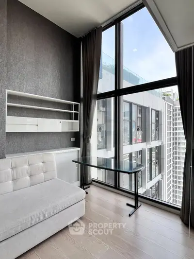 Modern living room with floor-to-ceiling windows and sleek furniture in a high-rise building.