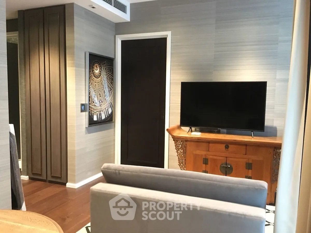 Stylish living room with modern decor and flat-screen TV, featuring elegant furniture and wall art.
