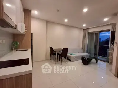 Modern open-layout living room with sleek kitchen and balcony view
