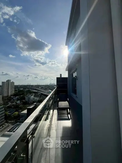 Stunning high-rise balcony with panoramic city views and modern glass railing.