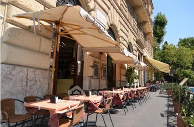 Charming outdoor cafe seating along a historic building facade, perfect for enjoying a sunny day.