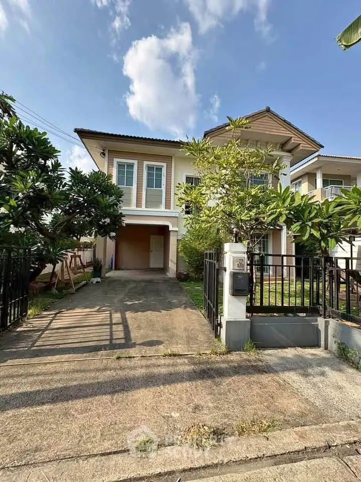 Charming two-story house with driveway and lush greenery, perfect for family living.