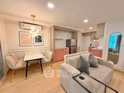 Chic modern living room with open kitchen, stylish decor, and cozy seating area in a contemporary apartment.