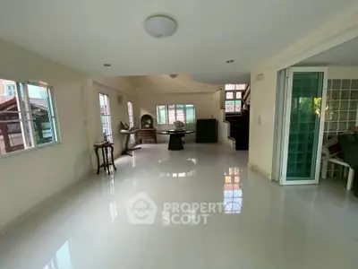 Spacious living room with large windows and glossy tile flooring in a modern home.