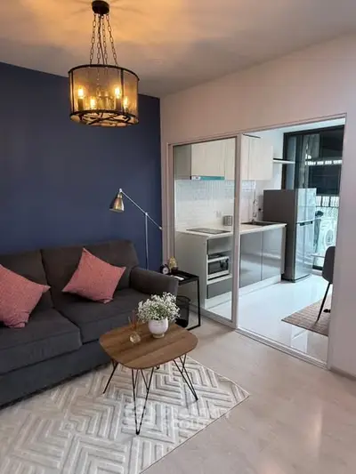Modern living room with stylish decor and open kitchen layout in a cozy apartment.