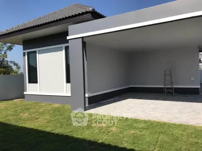Modern single-story house with spacious garage and lush green lawn.