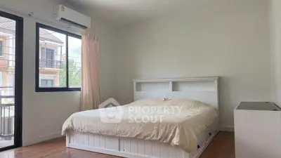 Spacious bedroom with large window and modern air conditioning unit