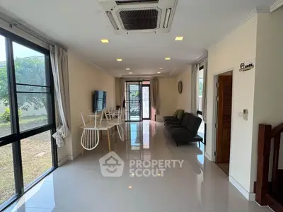 Spacious living room with modern decor and large windows overlooking garden