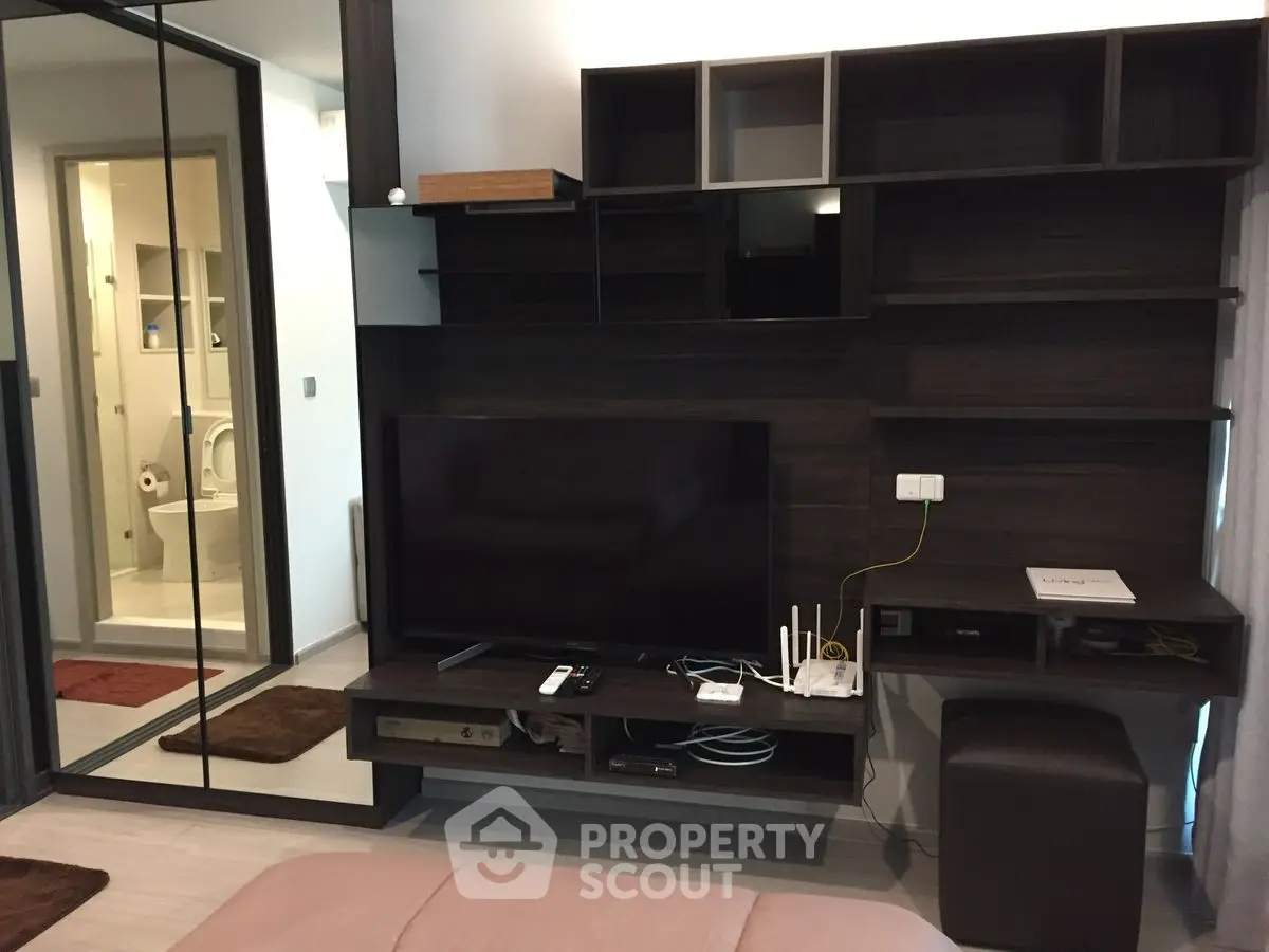 Modern living room with sleek entertainment center and mirrored closet doors