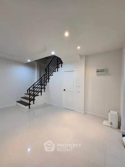 Spacious modern living room with sleek staircase and minimalist design