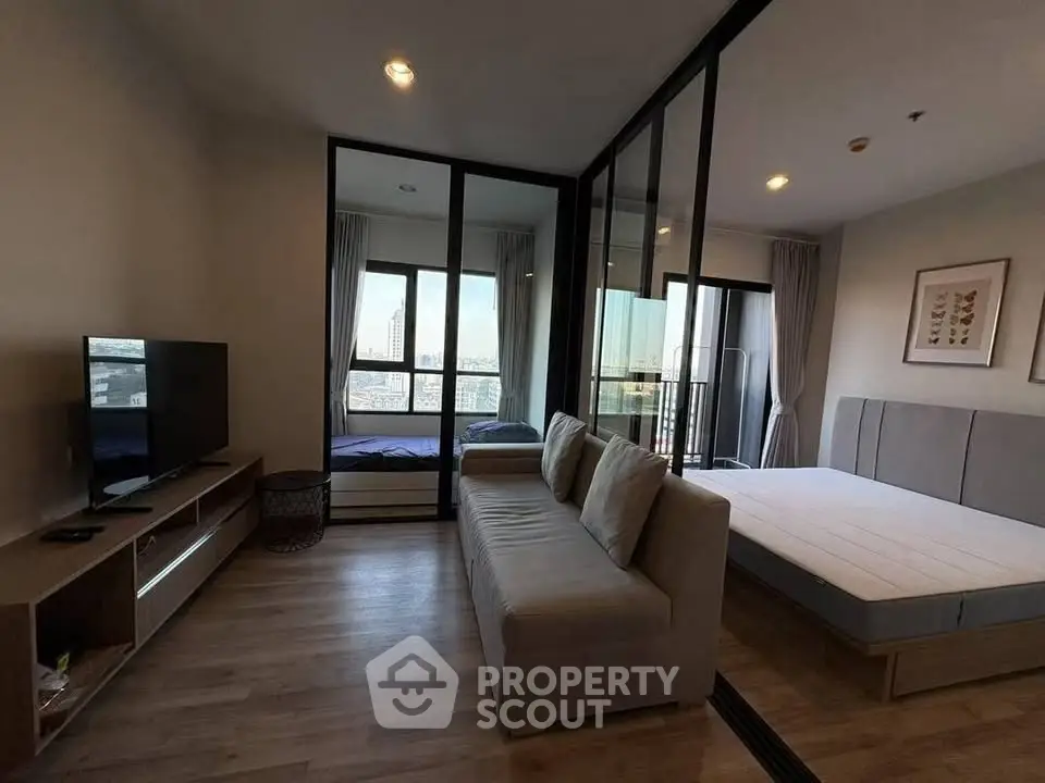 Modern studio apartment with glass partition, cozy living area, and city view.