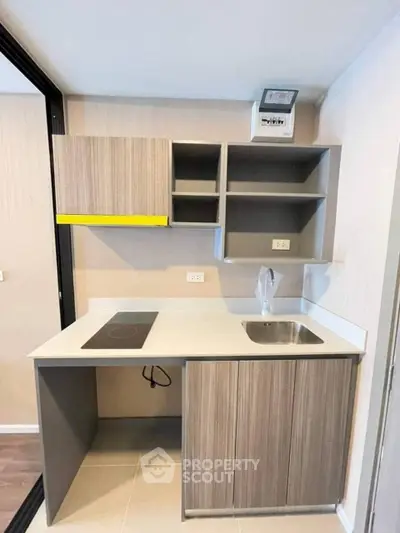 Compact modern kitchen with sleek cabinetry and electric stove