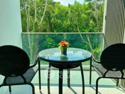 Charming balcony with lush green view and cozy seating area.