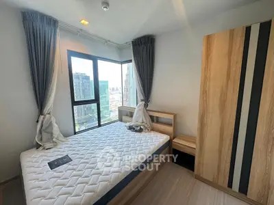 Modern bedroom with city view, featuring a large window and stylish wooden furniture.