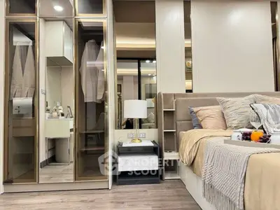 Luxurious bedroom with modern decor and mirrored wardrobe doors, featuring cozy bedding and stylish lighting.