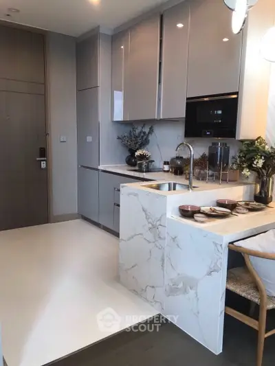Modern kitchen with sleek cabinetry and marble countertops in a stylish apartment.