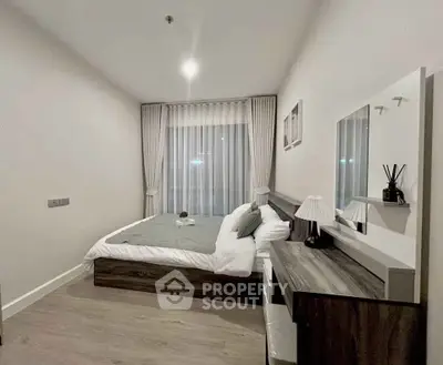 Modern bedroom with stylish decor and large window in a contemporary apartment.