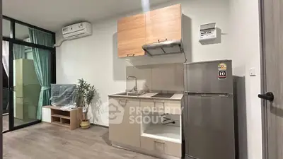 Modern compact kitchen with sleek appliances and stylish cabinetry in a cozy apartment setting.
