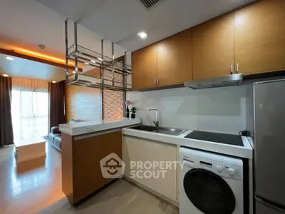 Modern open-layout kitchen with integrated appliances and cozy living area