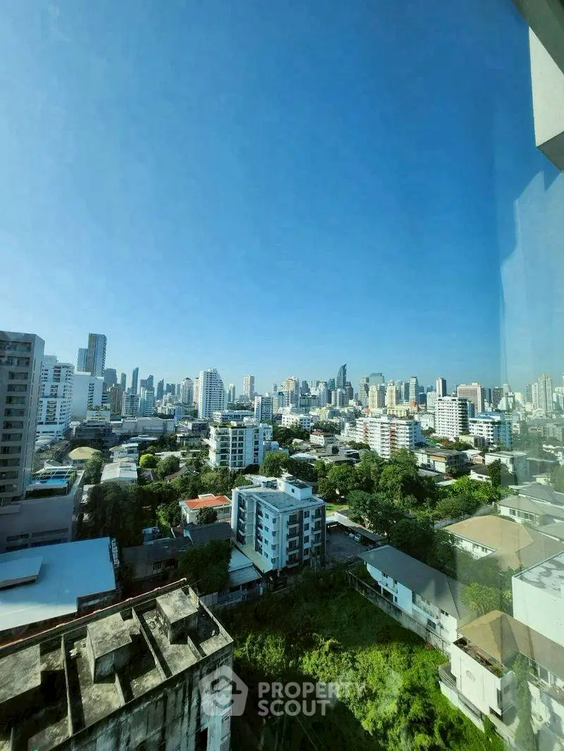 Stunning cityscape view from high-rise building, showcasing urban skyline and lush greenery.