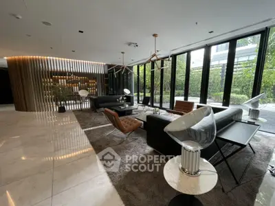 Luxurious modern living room with elegant furniture and large windows overlooking greenery.